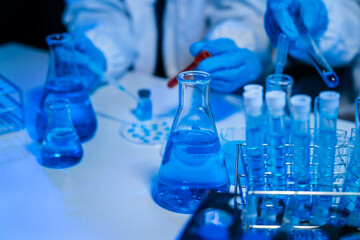 Science and medicine, scientist analyzing and dropping a sample into a glassware, experiments containing chemical liquid in laboratory on glassware, innovative and technology.