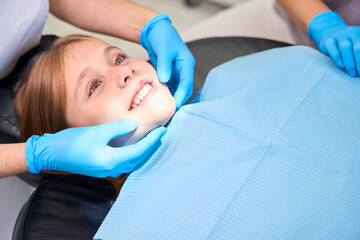 Smiling teenage girl placed in a chair for dental procedures