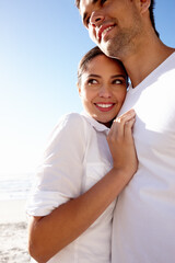Obraz premium Happy, hug and couple on beach on holiday for bonding, relax together and relationship by ocean. Dating, travel and man and woman embrace for romance on anniversary, vacation and weekend in nature
