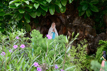 Statue of Our lady of grace virgin Mary view with natural background in the rock cave at Thailand. selective focus.