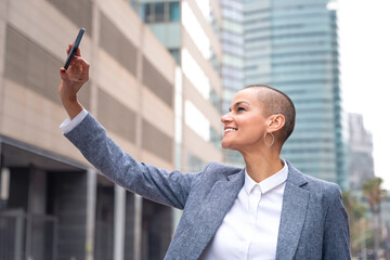 Stylish business woman, smiling making a self-portrait outdoors.