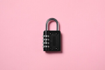 Steel combination padlock on pink background, top view