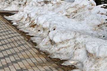 Drifts of dirty snow in a park in early spring