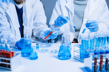 Two Scientist mixing chemical liquids in the chemistry lab. Researcher working in the chemical laboratory
