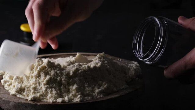 Man mixing a healthy, dry, powdered sports protein with a measuring spoon in a bottle, embodying the concept of a vibrant life.