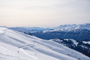 Expansive winter Mountain vista under a pale sky. - 770481409