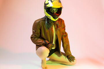 Sensual Sexy Caucasian Female Motorcyclist Posing In Leather Protective Jacket And Helmet While Sitting on Hunkers - 770484237