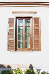 Vintage window with shutters on the wall of an old house..window in Cunda Turkey old construction and wood the historical