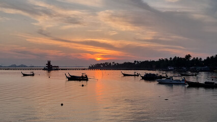 A collection of small boats peacefully float on the calm waters, creating a serene and picturesque scene