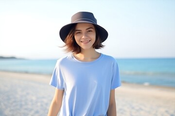 A woman in azure tshirt and jeans smiles on beach - 770493014