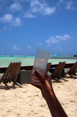 Having a drink in a Caribbean beach bar with wooden deckchairs - 770493216