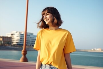 A woman in red t-shirt and jeans smiles on beach - 770493263