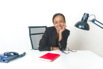 smiling business woman in a black suit is sitting at her desk with a positive attitude