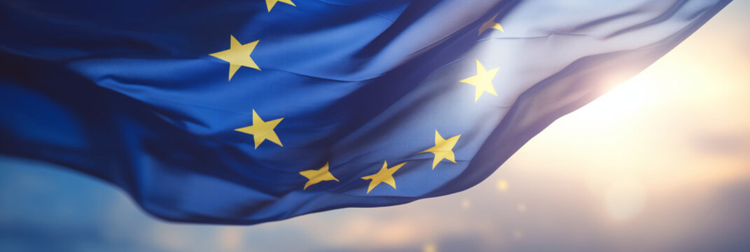 Flag of European Union waving in the breeze against a sunset sky. Banner with EU flag.