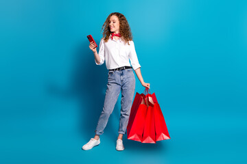 Photo portrait of pretty young woman shopping bags hold device dressed stylish white clothes...
