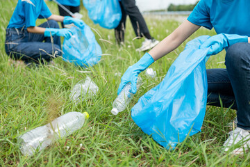 Happy volunteer people group charity with garbage bags cleaning up in park. Corporate social...
