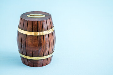 Wooden Barrel Money Box on Blue Background with Copy Space