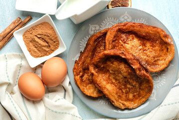 Plate with traditional homemade Torrijas, cinnamon,milk and eggs. Typical Lent and Easter dessert in Spain