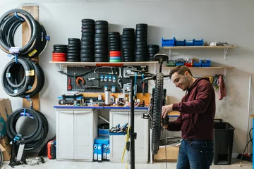 Fotobehang workshop scene where a mechanic is replacing the chain on a mountain bike © Jordi Mora