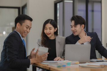 A group of employees happily work together in the office while discussing work that was completed on time as ordered by their boss, A group of entrepreneurs had fun working together.