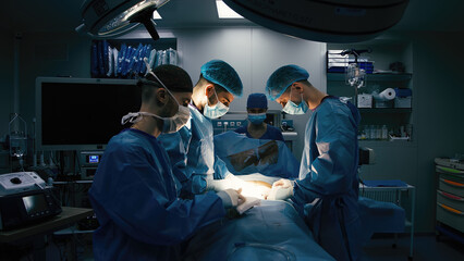 Close-up of mixed race surgeons in uniform working on an operation in a modern operating room....