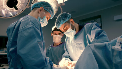 A group of professional surgeons in the operating room. Close-up of a surgical operation. Plastic surgery. Health. Surgery in a private clinic. Beauty and health. - obrazy, fototapety, plakaty