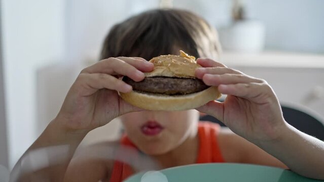 Little Boy Holds Burger In Front Of His Eyes To Check The Doneness Of The Meat