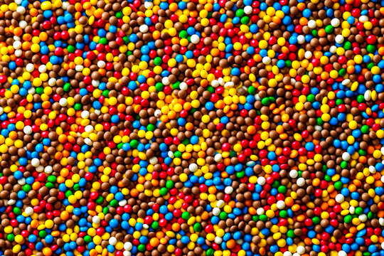 A top view of countless multicolored chocolate candies creating a rich and textural mosaic