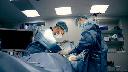 A group of professional surgeons in the operating room. Close-up of a surgical operation. Plastic...
