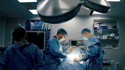 Close-up of surgeons in protective clothing in a modern operating room. Healthcare, surgery and...