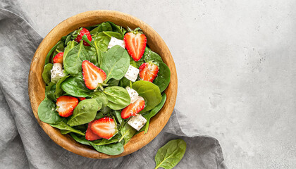 spinach salad. Fresh spinach salad with strawberry and goat cheese on bowl and copy space, healthy salad, salad bowl - obrazy, fototapety, plakaty
