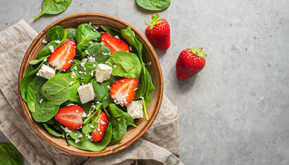 spinach salad. Fresh spinach salad with strawberry and goat cheese on bowl and copy space, healthy salad, salad bowl - obrazy, fototapety, plakaty