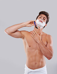 Man, shave and cream with razor blade for grooming, hygiene or facial treatment on a gray studio...