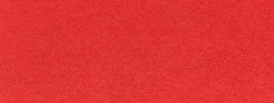 Texture of old bright red color paper background, macro. Structure of a vintage craft scarlet cardboard.
