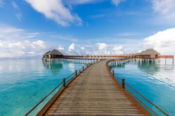 Fototapeta na wymiar Maldives water villas paradise background. Tropical landscape, seascape with long pier, water villas, amazing sea sky and lagoon beach, tropical nature. Exotic tourism destination, summer vacation