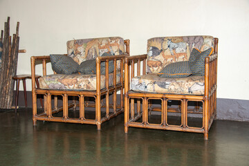 two bamboo chairs with animal drawings on the cushions