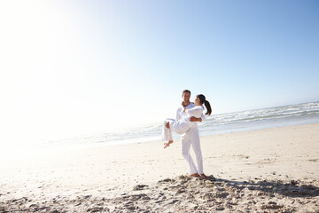 Couple, beach and carrying with blue sky for valentines day, support or outdoor summer holiday...