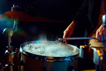 Close-up of drum with water drops jumping from stick's strike. Creative and impressive live performance. Concept of music, instruments, concert, sound, equipment, festival