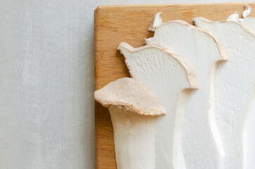 Eryngii mushroom on a wooden cutting board. The process of cooking Gochujang King Oyster Mushrooms....