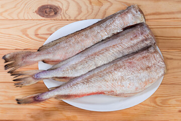 Cooled carcasses of red cod on dish on rustic table