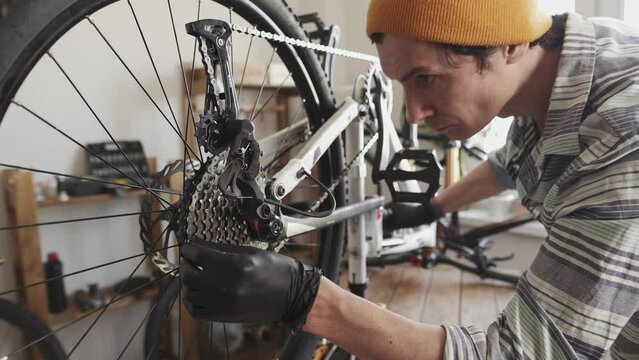 Man fixing a mountain bike in a workshop. Concept of preparation for the new season, repair and maintenance