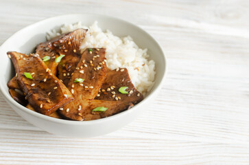 Eryngii mushroom fried with sesame and green onion and white boiled rice in a gray bowl. Dishes Gochujang King Oyster Mushrooms. Traditional Korean cuisine. Horizontal orientation. Copy space