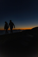 Sagoma di persone al tramonto sulla spiaggia