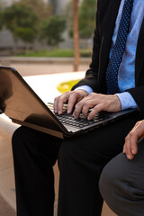  Business on the move: Businessman working on his laptop on the street. Man Hands Type On His Laptop Outdoors - obrazy, fototapety, plakaty