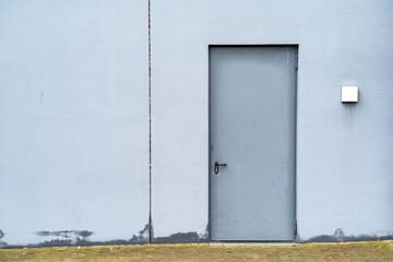 gray metal door in white house wall