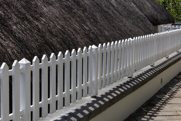 White wooden fence in the garden. Selective focus and small depth of field.