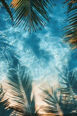 Frame made of various leaves of tropical plants and shadows on the background of the blue water with space for text, Top view