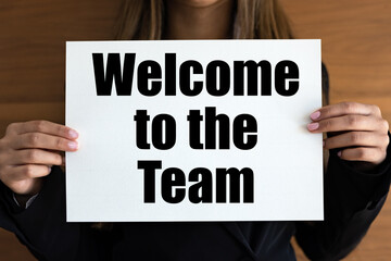 Welcome to the team. Woman with white page, black letters. Greeting, motivation, team spirit.