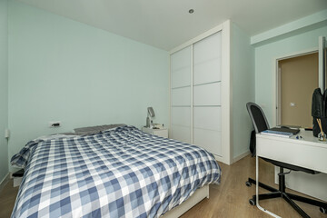 room in a house dedicated to a double bedroom, bed with shredded duvet and a wardrobe with two...