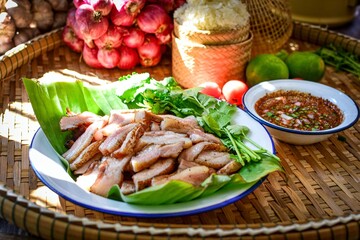 Thai Grilled Pork Neck with spicy dipping sauce and sticky rice with thai vegetables, Isan food, thai kitchen background 